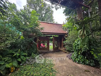 Charming traditional entrance surrounded by lush greenery, offering a serene and inviting atmosphere.