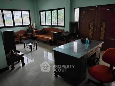 Spacious living room with traditional wooden furniture and large windows