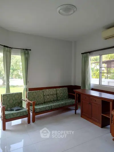 Charming living room with garden view, featuring classic wooden furniture and natural light.