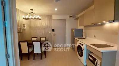 Modern kitchen with dining area featuring washing machine and sleek appliances.