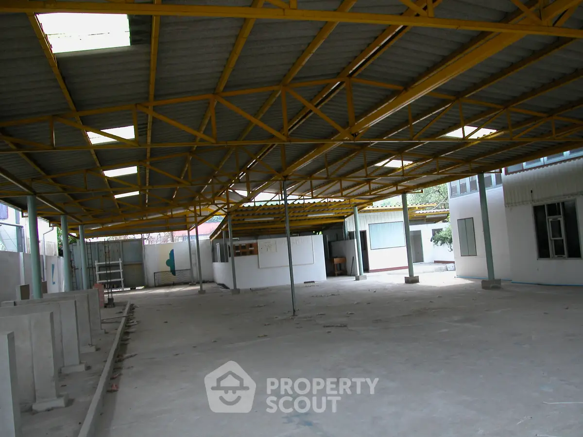 Spacious industrial warehouse with high ceilings and ample natural light, perfect for storage or manufacturing.
