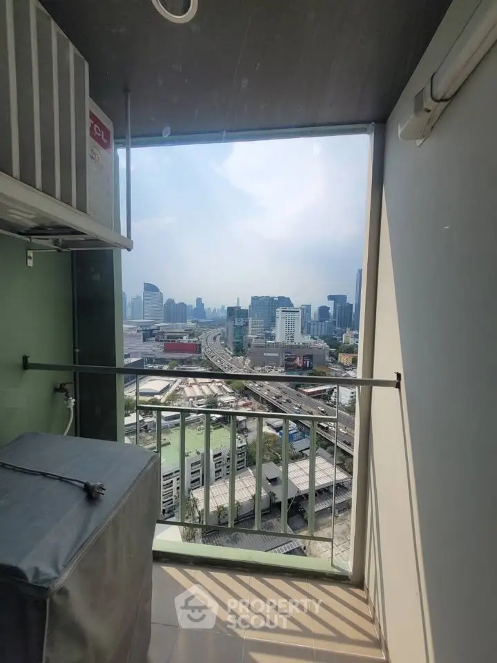 Stunning city view from a high-rise balcony with modern railings and urban skyline.