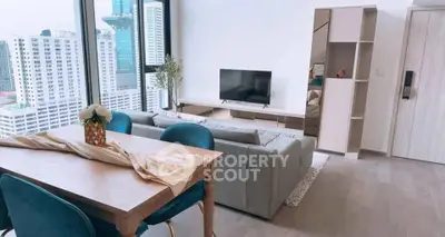 Modern living room with city view, stylish furniture, and elegant decor in high-rise apartment.