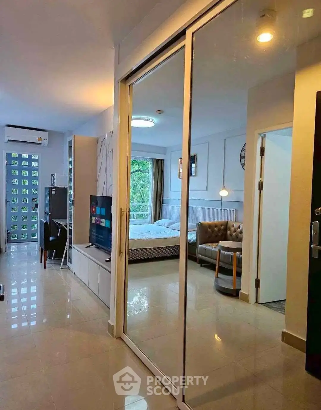 Modern apartment interior with open layout, featuring a cozy living room and bedroom with large windows.