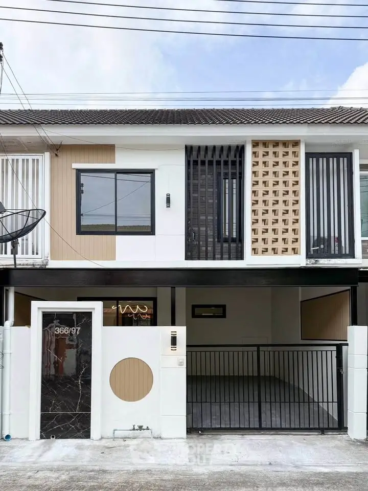 Modern townhouse exterior with unique facade design and gated parking area.