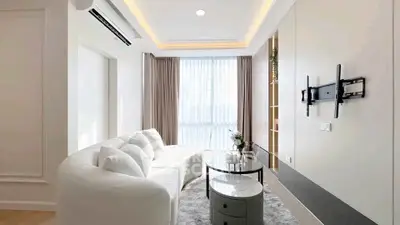 Modern living room with sleek design, featuring a cozy white sofa and elegant decor.