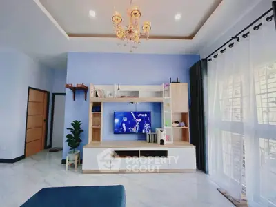 Spacious living room with elegant chandelier and modern entertainment center