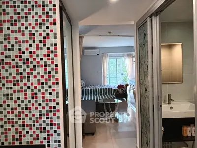 Modern studio apartment with stylish mosaic wall and cozy living area