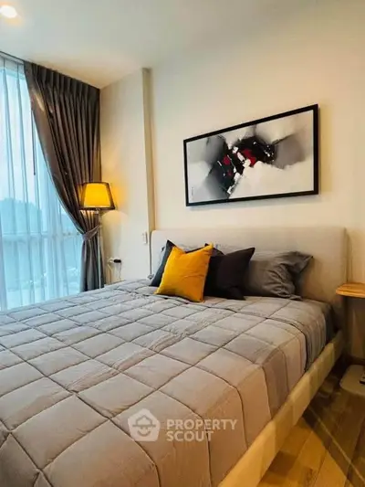 Cozy bedroom with modern decor and large window, featuring a stylish bed and elegant lighting.