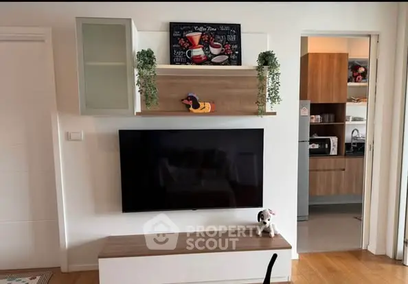 Modern living room with wall-mounted TV and stylish kitchen view