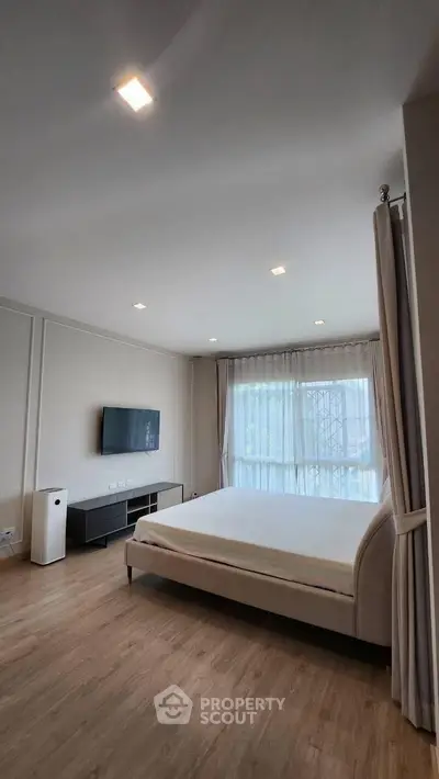 Spacious modern bedroom with large window and minimalist decor