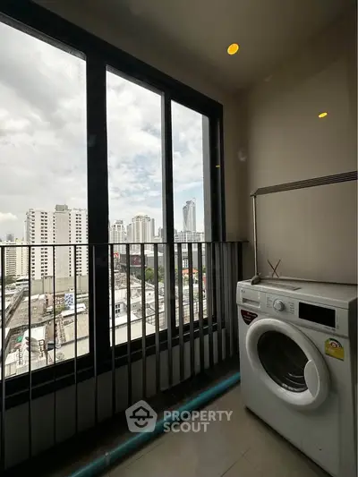High-rise apartment with city view and washing machine on balcony