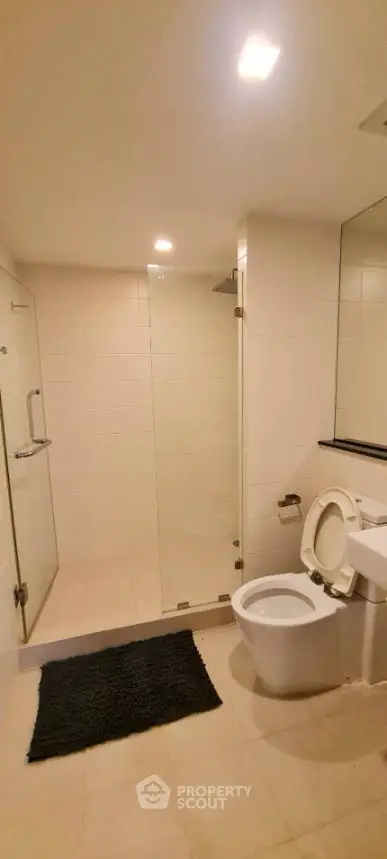 Modern bathroom with glass shower and sleek fixtures in a contemporary apartment.