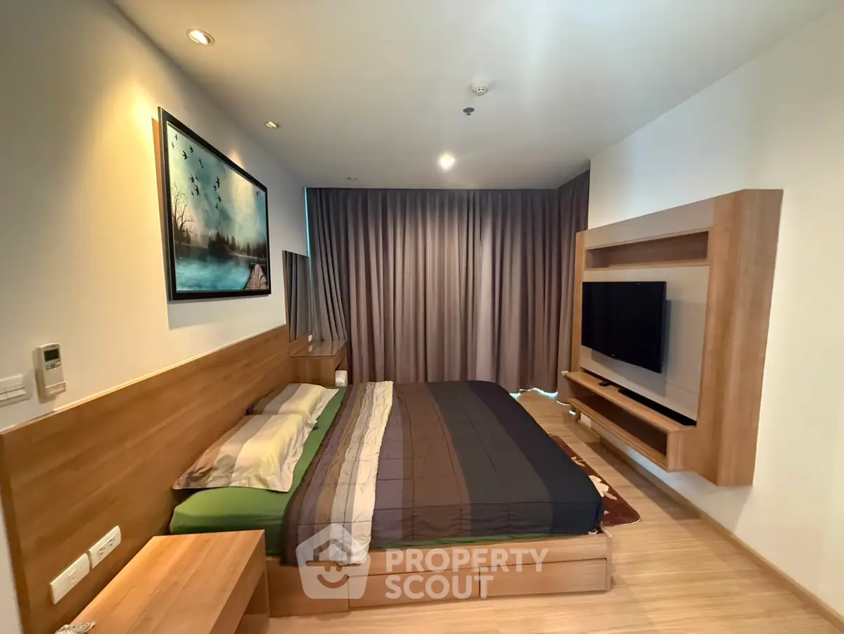 Modern bedroom with wooden furniture and wall-mounted TV, featuring elegant decor and cozy ambiance.