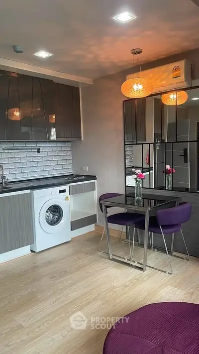 Modern kitchen with washing machine and dining area in stylish apartment