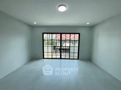 Spacious living room with large sliding glass doors leading to a balcony, offering ample natural light.