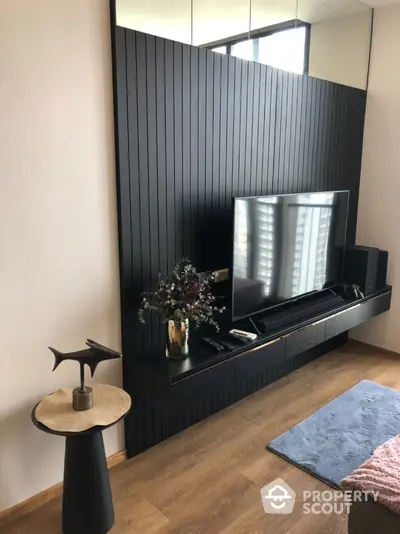 Modern living room with sleek black panel wall and mounted TV