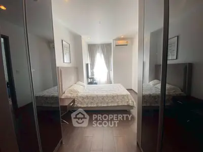 Spacious bedroom with modern decor and large windows for natural light.