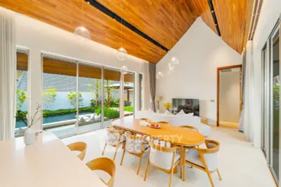 Spacious modern living room with high ceilings and large windows overlooking a garden.
