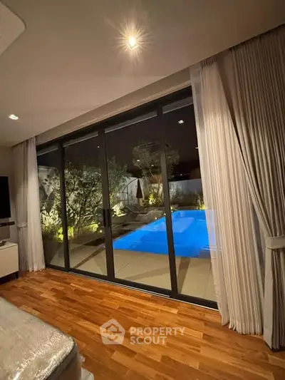 Luxurious living room with pool view and elegant wooden flooring