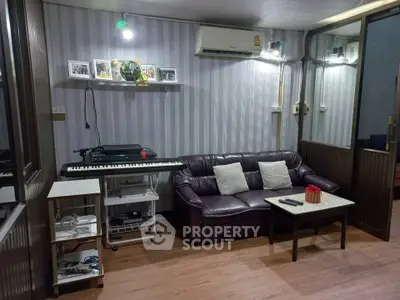Cozy living room with leather sofa, keyboard, and modern decor in stylish apartment.