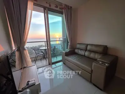 Cozy living room with stunning ocean view and balcony seating at sunset.