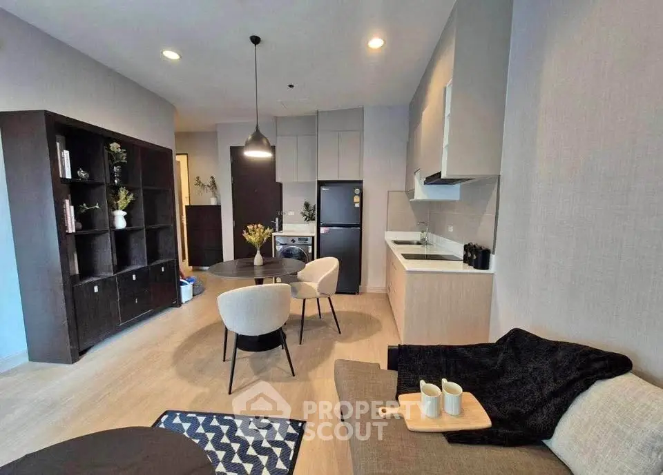 Modern open-layout living room with stylish furniture and kitchen area, perfect for urban living.