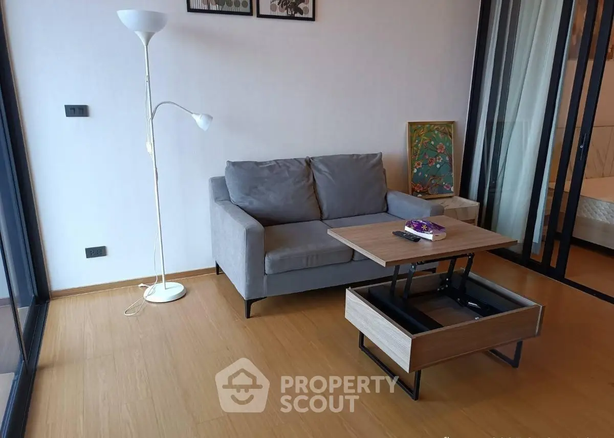 Modern living room with stylish sofa and adjustable coffee table in a cozy apartment.