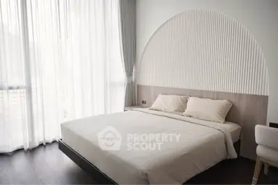 Modern bedroom with elegant design and large windows offering natural light.