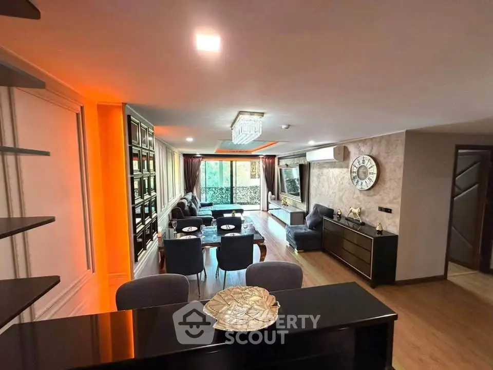 Luxurious living room with modern decor and ambient lighting, featuring a spacious layout and elegant furnishings.
