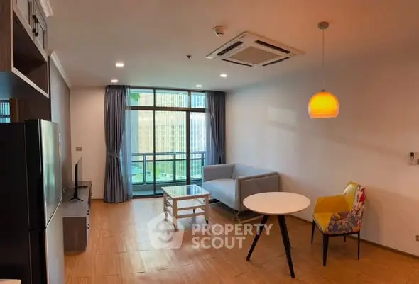 Modern living room with stylish furniture and large windows offering city views.