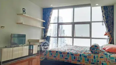 Modern bedroom with city view, large windows, and stylish decor in high-rise apartment.