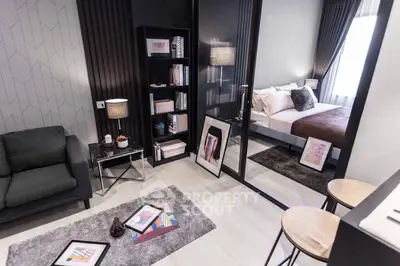 Modern living room with stylish decor and cozy bedroom view through glass partition.