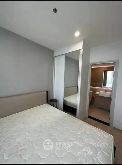 Modern bedroom with mirrored closet and ensuite bathroom