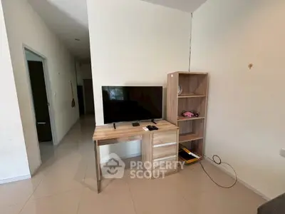 Modern living room with sleek TV stand and bookshelf, ideal for cozy entertainment setup.
