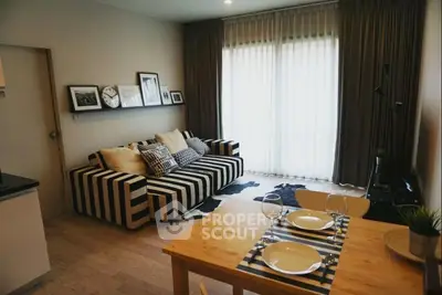 Chic modern living room with striped sofa and dining area, perfect for urban living.