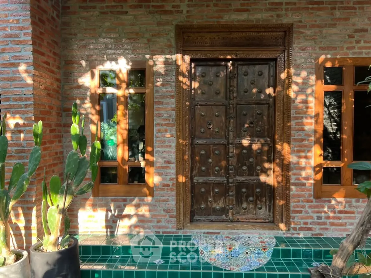 Charming brick exterior with ornate wooden door and lush greenery