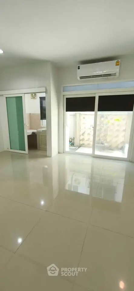 Spacious modern living room with large windows and air conditioning, perfect for comfortable living.