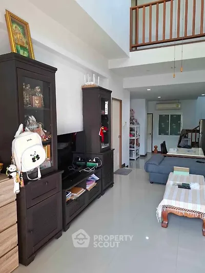 Spacious living room with modern furniture and high ceiling, perfect for family gatherings.