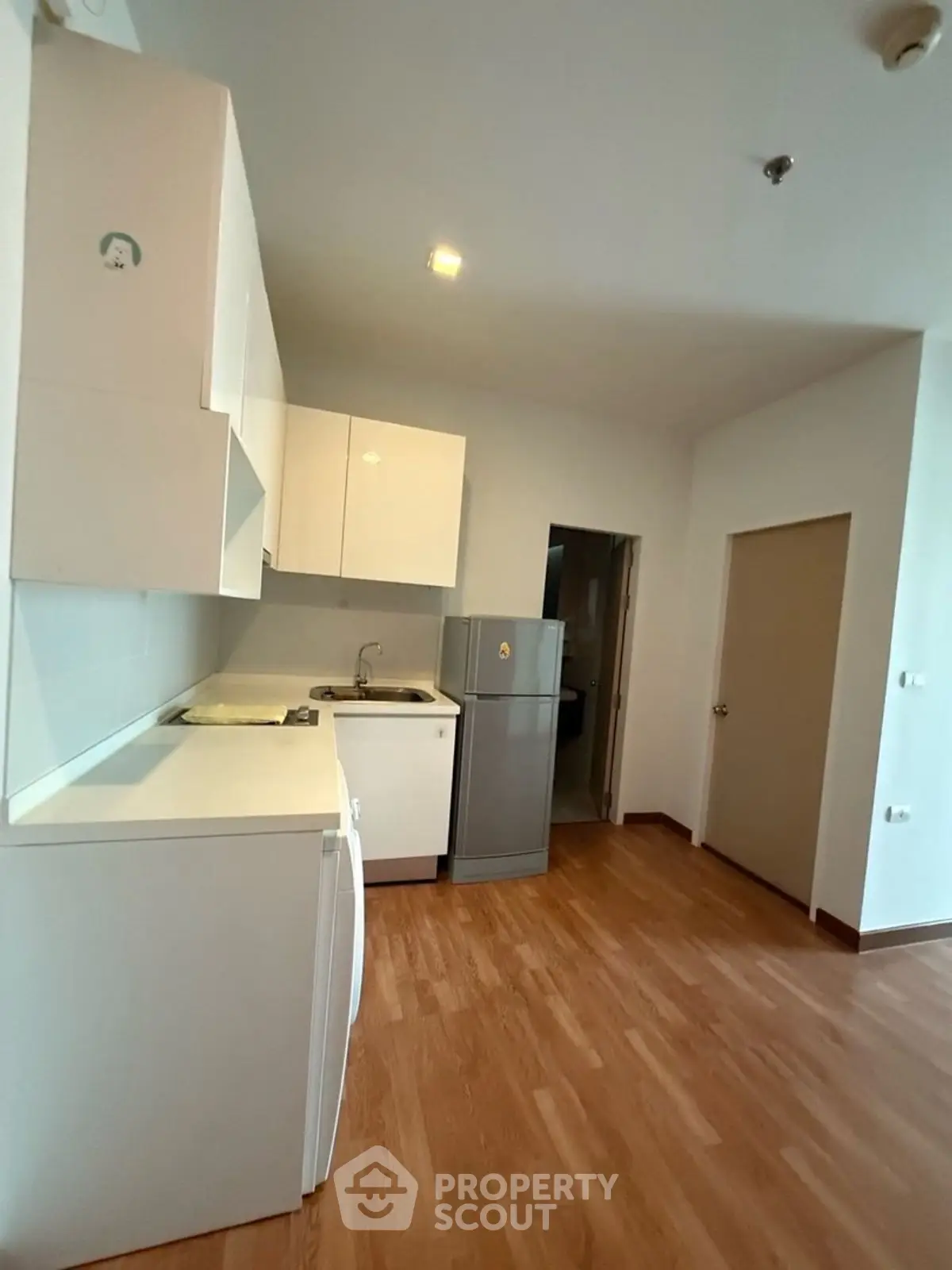 Modern kitchen with sleek white cabinets and hardwood flooring
