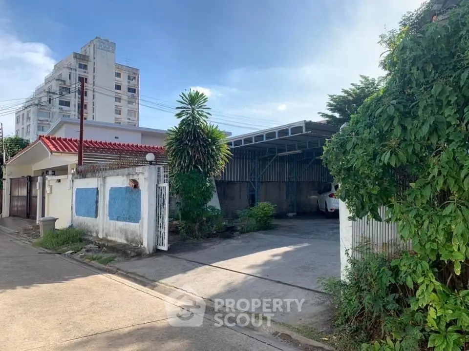Spacious residential property with gated parking and lush greenery, ideal for urban living.