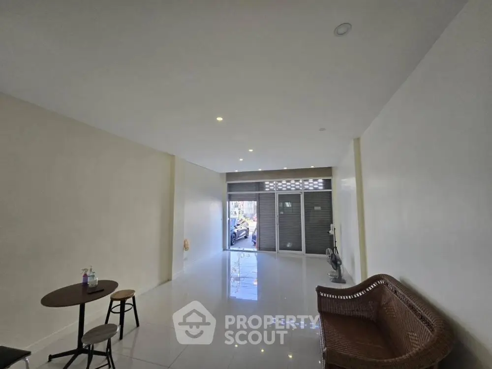 Spacious and bright living area with glossy tiled floors, leading to a welcoming entrance, perfect for modern living.
