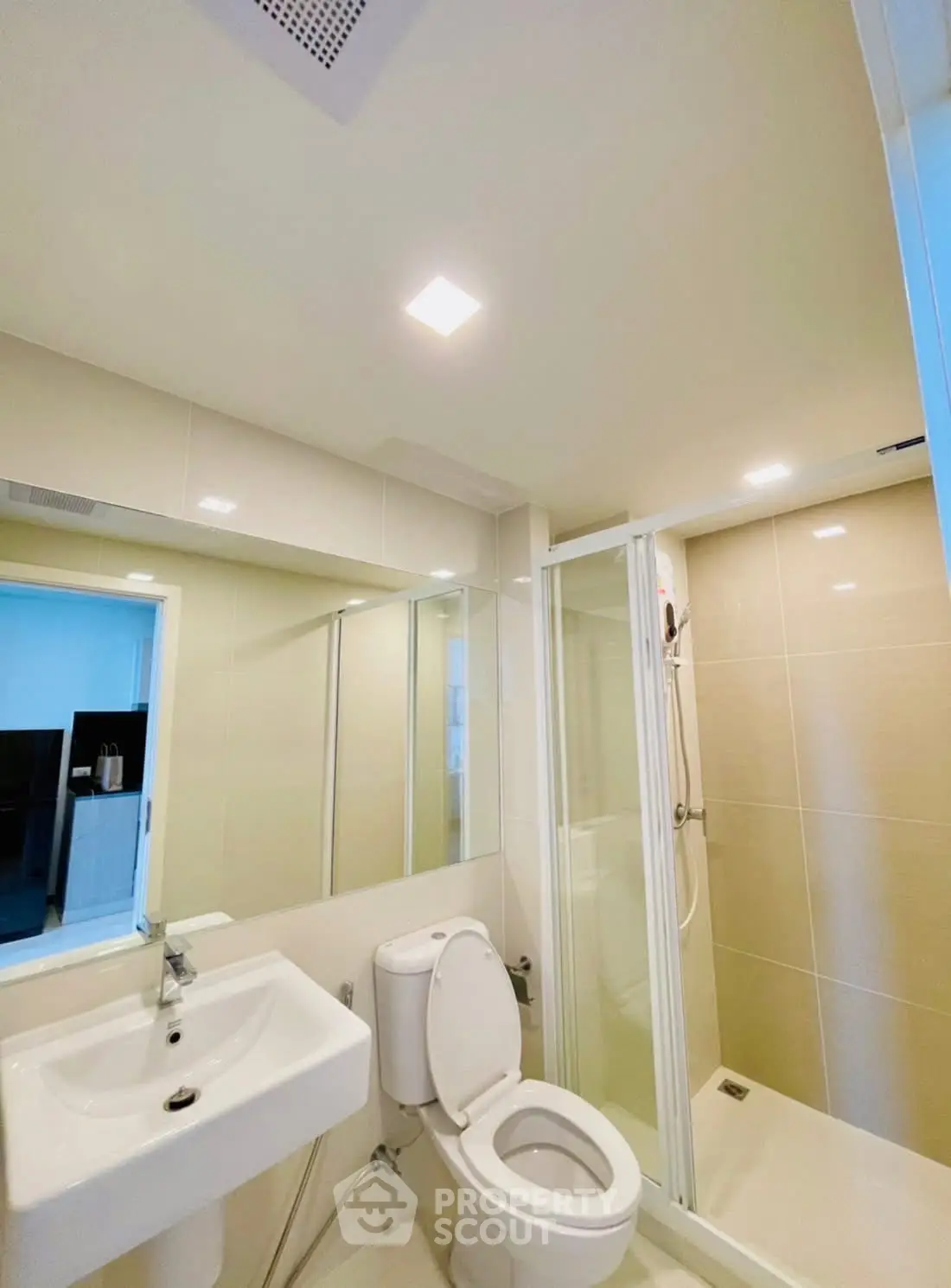Modern bathroom with sleek fixtures and glass shower enclosure in a contemporary apartment.