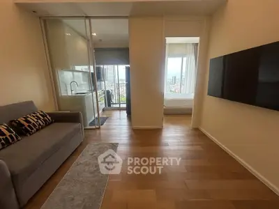 Modern apartment interior with open layout, featuring a cozy living area and a glimpse of the bedroom.