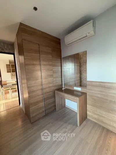 Modern wooden wardrobe and vanity in a stylish apartment interior with air conditioning.