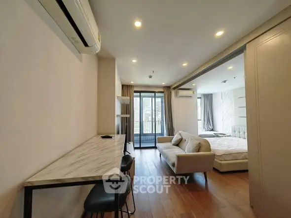 Modern apartment interior with open layout, featuring a cozy living area and stylish bedroom.