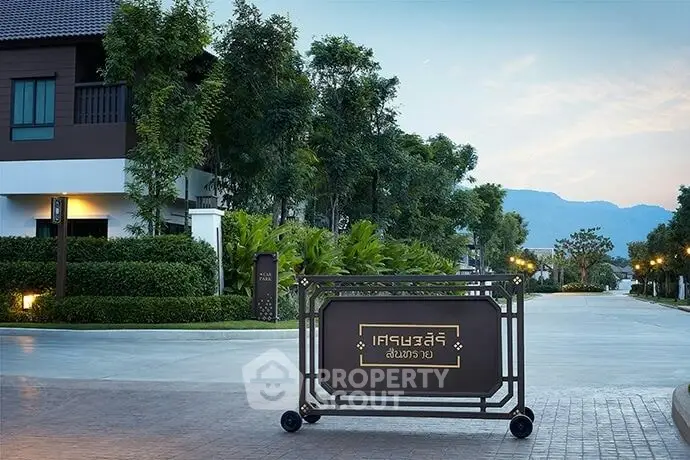 Luxurious residential entrance with scenic mountain view and lush greenery.