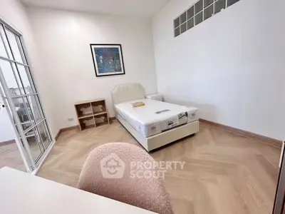 Spacious bedroom with modern decor and natural light, featuring a comfortable bed and stylish flooring.