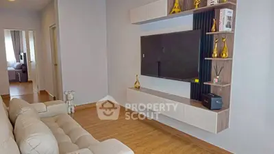 Modern living room with stylish wall-mounted TV unit and cozy beige sofa.