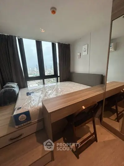 Modern bedroom with large window offering city views, featuring a cozy bed and stylish wooden furniture.